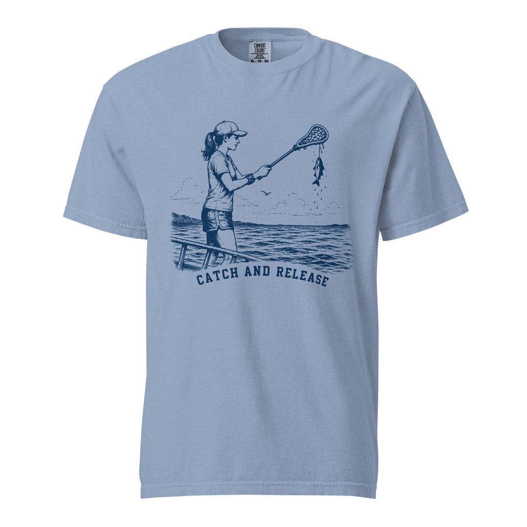 Lacrosse shirt with the GO2X Catch and Release design, a girl on a dock holding a lacrosse stick with a fish hanging from the head