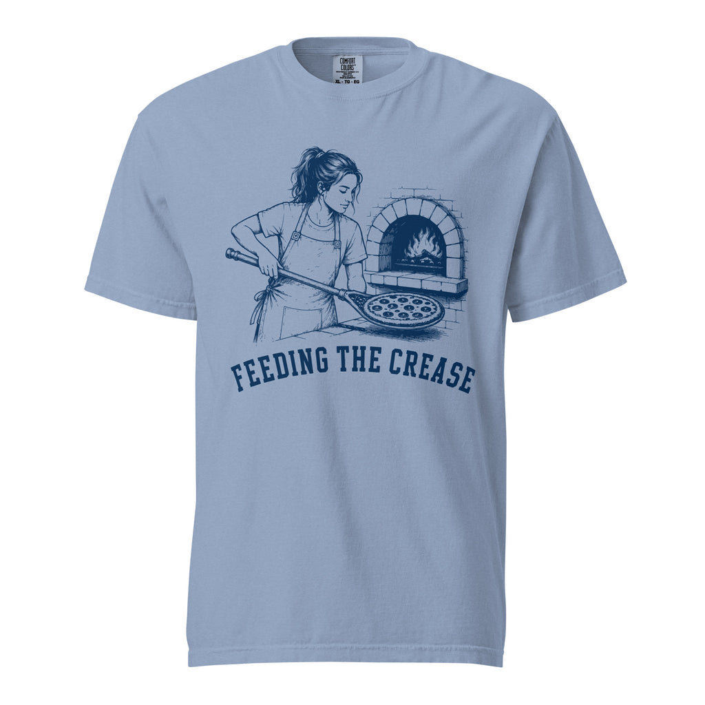 Lacrosse shirt with the GO2X Feeding the Crease design, a woman sliding a pizza into a wood-fired oven with a lacrosse stick